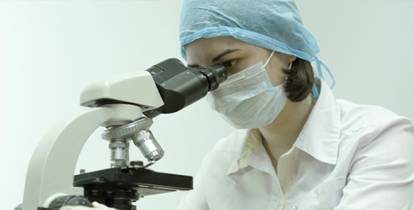 A Doctor Working With a Microscope