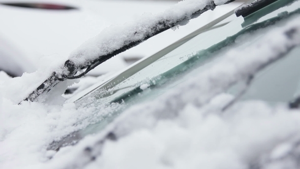  Wipers Brushing Away Snow From a Car's Windshield