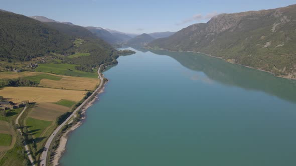 Aerial shot flying over a river snaking through a mountain valley in Norway