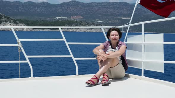 Tourist Woman Sunbathing on Upper Deck of Yacht. Red Flag on Turkey. On the Way To Famous Kekova