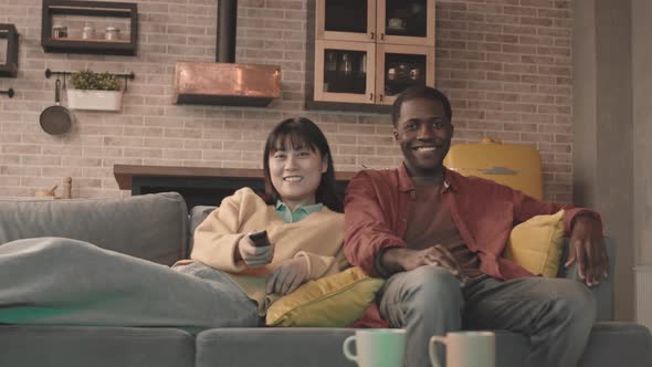 Multiethnic Couple Watching TV at Home