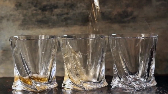 Pouring Whiskey In Three Glasses