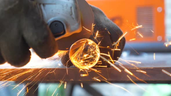 Detail View on Metal Processing with Circular Saw. Hands of Mechanic Holding Instrument and Grinding