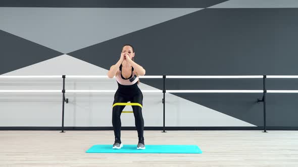 Woman Training Legs Using Fitness Band