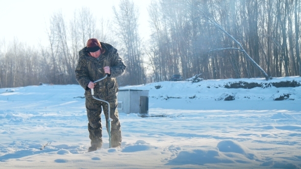 Ice Fisherman Drill On Winter Lake