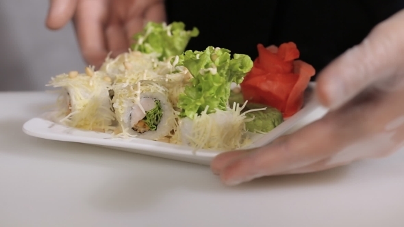 Chef Flips a Plate Of Sushi Rolls