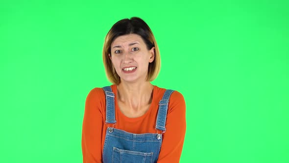 Girl Listens Carefully, Waving Her Hands in Indignation, Shrugs. Green Screen