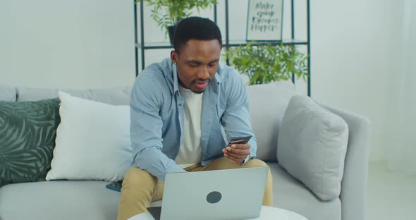 Man Uses a Laptop for Online Shopping at Home