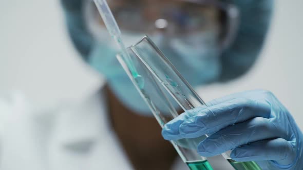 Female Scientist Observing Reaction in Test Tubes After Mixing Two Substances