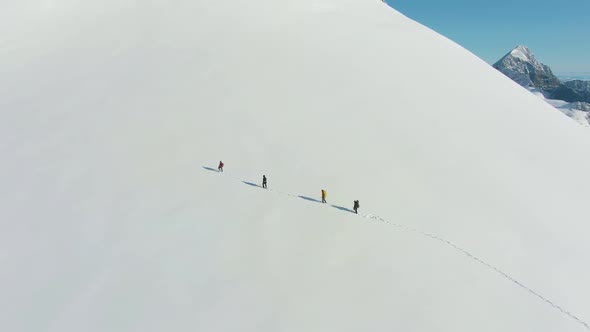 Mountaineers Are Advancing As Roped Team in Snowy Mountains. Aerial View