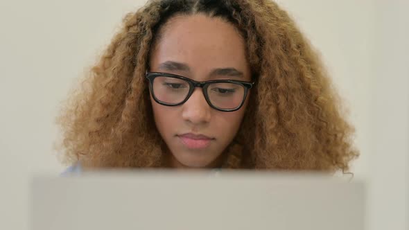 Portrait of African Woman Reacting to Loss While Using Laptop