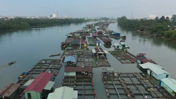 Floating fish farming community in Bien Hoa on the Dong Nai river, Vietnam on a sunny day.Drone sho