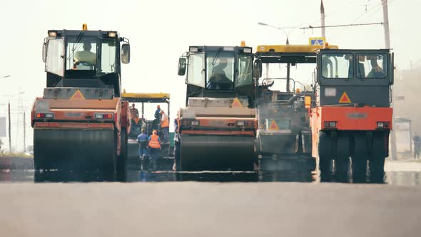 Front View of Asphalt-placing Machines and Workers. Road Construction Process.