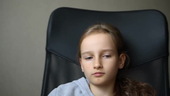 Little Sad Girl is Sitting on Black Office Chair Punishment Serious Face