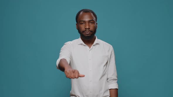 Portrait of Young Man Showing Thumbs Up and Thumbs Down Sign