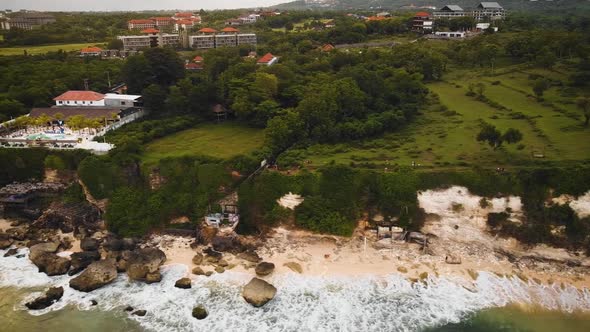 Beautiful Bingin beach with exotic cliffs houses and hotel located in Bali, Indonesia. This drone fo