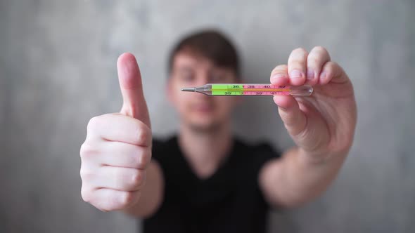 A Good Measure of Body Temperature. A Young Man Is Happy To Measure Body Temperature