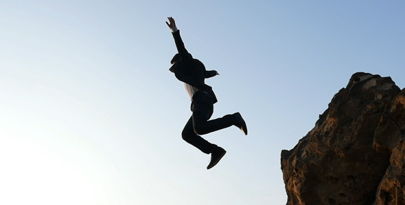 Businessman Jumping From A Cliff 