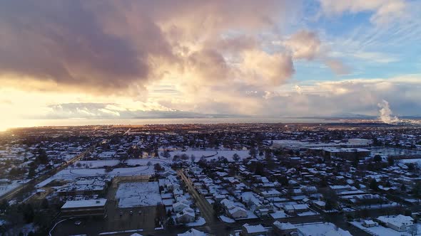 Hyper lapse flying over snow covered neighborhood towards sunset