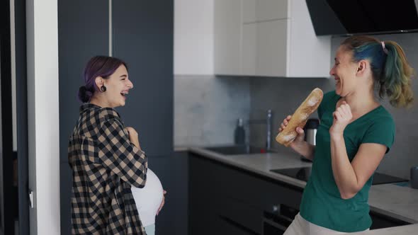 Pregnant Woman and Her Mother in Kitchen Having Fun and Dancing on Kitchen