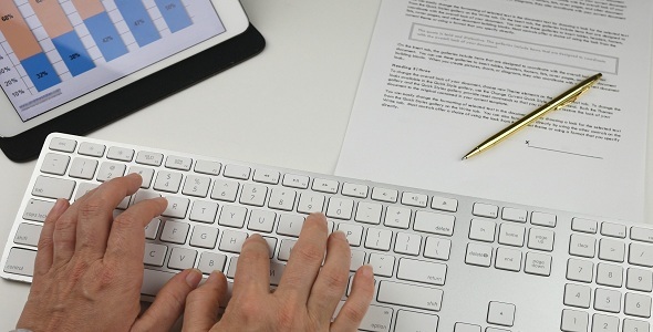 Womans hands Typing on Keyboard in Office