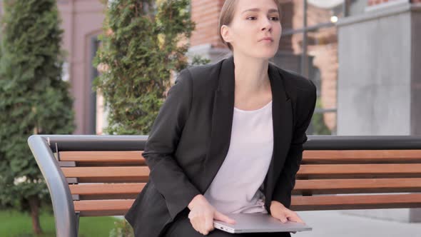 Young Businesswoman Leaving Bench after Closing Laptop