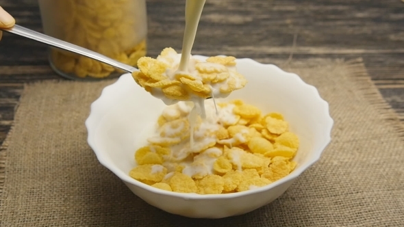 Fresh Milk Pouring Into a Bowl Full Of Cornflakes