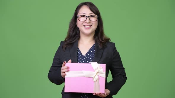Mature Beautiful Asian Businesswoman Holding Gift Box