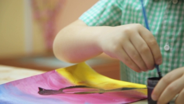 Boy Draws With a Brush On Paper