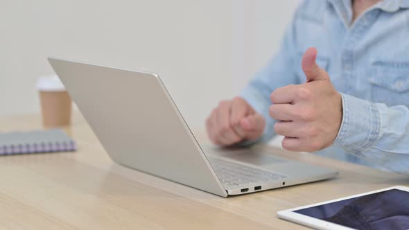 Thumbs Up By Man Typing on Laptop