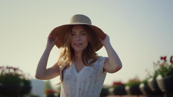 Attractive Girl Taking Off Sunhat in Sunny Day