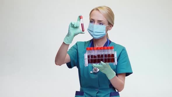 Medical Doctor Nurse Woman Wearing Protective Mask and Latex Gloves - Holding Blood Test Tube Rack