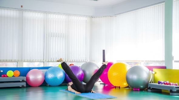 Fitness Woman Taking Legs Stretch Poses On The Floor