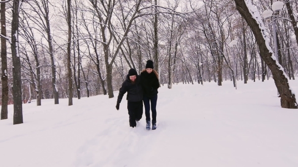 Winter Fun - Couple Walking On Snow-covered Path And Laughs