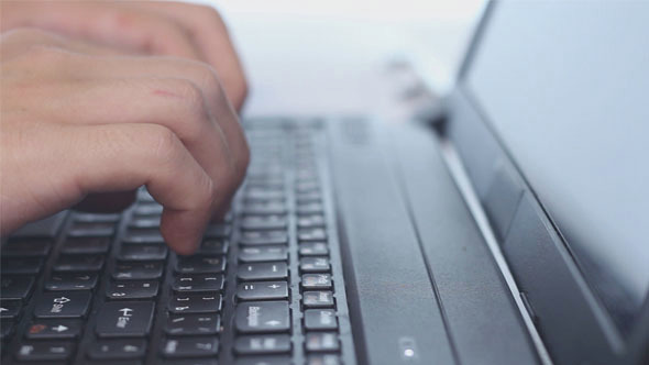 Businessman Typing on a Laptop Keyboard alt