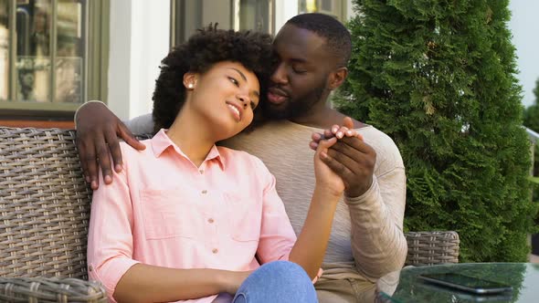 Cute Afro-American Couple Relaxing in Outdoor Cafe, Hugging and Talking, Love