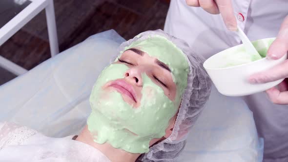 Beauty and Cosmetology Concept. Young Woman with Cream Mask in a Beauty Parlour