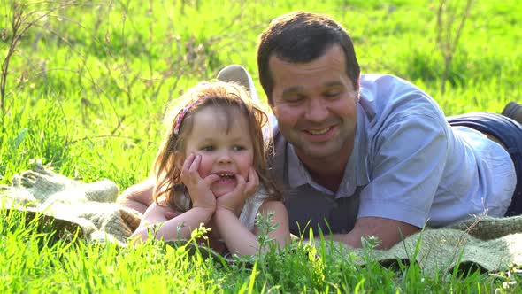 Happy Father and Daughter Resting on the Grass