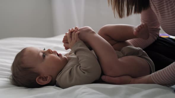 Video of caucasian little baby girl playing with mom in the bed. Shot with RED helium camera in 8K.