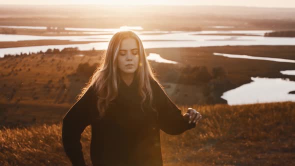 Young Woman in Black Clothes Training with a Sword While Sunset on Nature