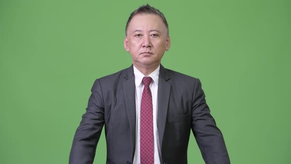 Mature Japanese Businessman with Arms Crossed