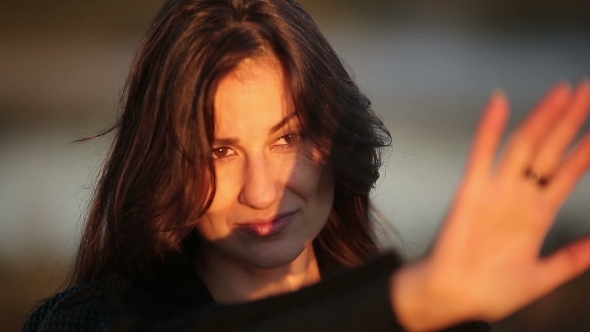Young Brunette Woman Enjoying The Sun Rays On Her Face During Sunrise