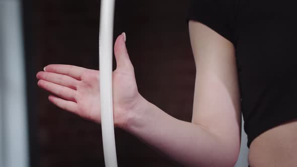 A Woman Gymnast Twists Hoop in Her Hand
