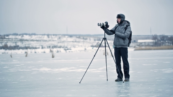 Photographer With Tripod In Winter
