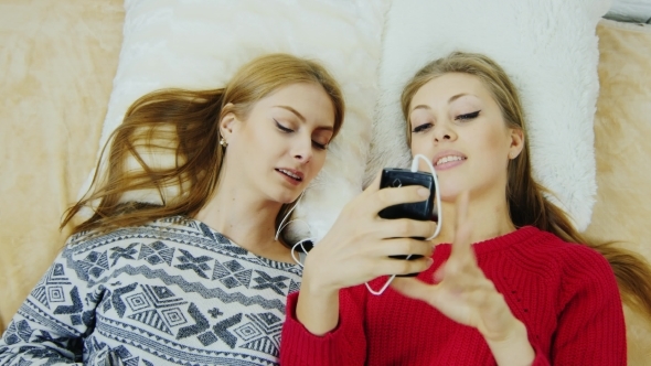 Two Attractive Girls Communicate With Friends By Phone