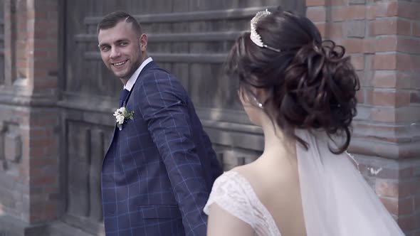 Close Backside View Bride and Fiance Join Hands and Run