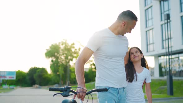 Dad and Daughter Walk Around Their Area After Cycling at Sunset