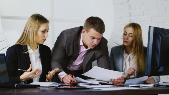 Business Team At Work, a Man And Two Women Working With Documents