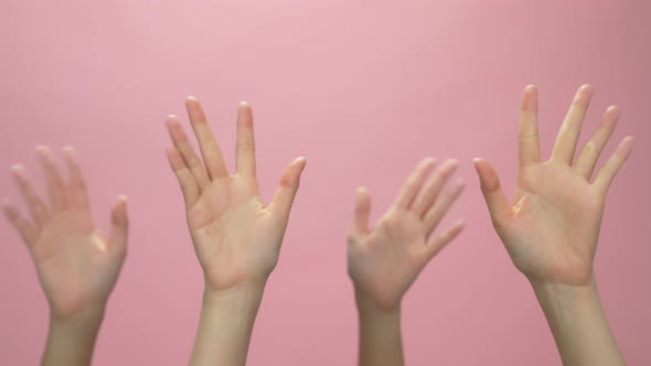 Close up of woman hand showing waving bye on the pink background.