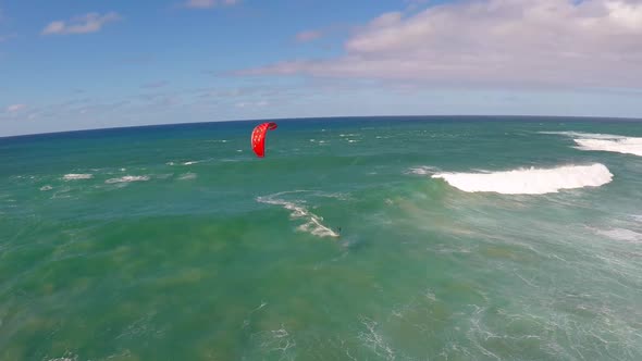 Aerial view of a man kitesurfing in Hawaii.